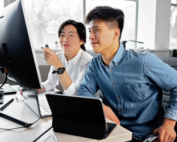 IT staff reviewing a computer screen together in an office, the team that handles PDPA data breach notification in Malaysia